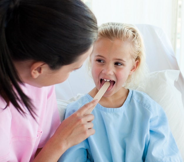 Medico femminile che esamina la gola di un bambino