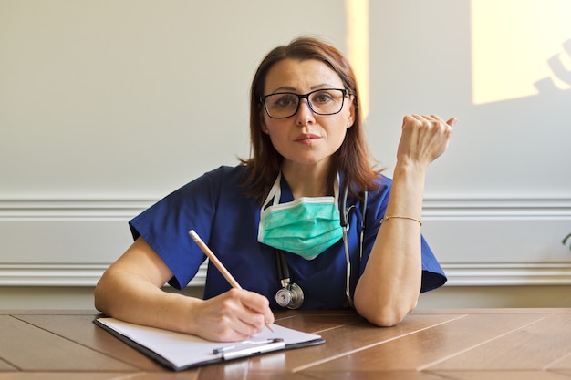 Medico femminile che esamina webcam. Videoconferenza, conversazione specialistica, consulenza, assistenza online ai pazienti