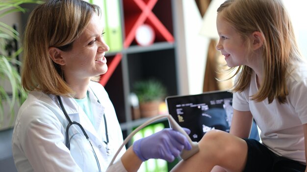 Medico femminile che fa l'esame di esame di ultrasuono per la ragazza alla medicina dell'ospedale per