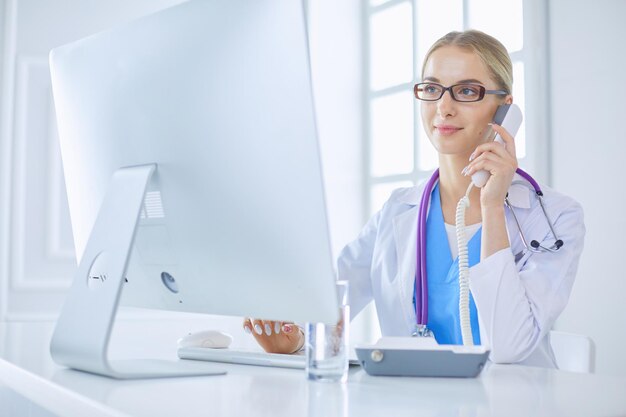 Medico femminile che ha una telefonata in studio medico