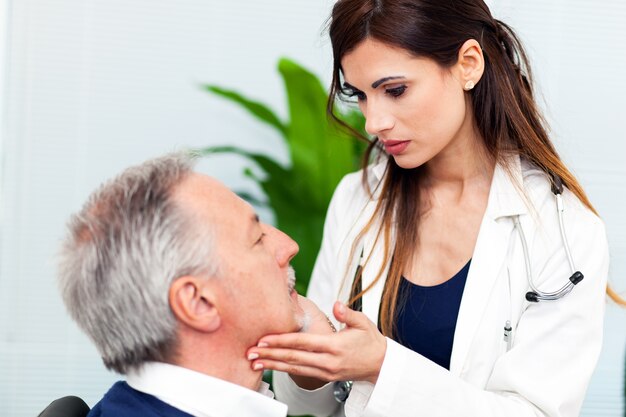 Medico femminile che visita un paziente controllando la sua gola