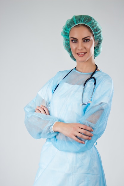 Medico femminile Chirurgo in scrub con cappello medico attraversato le braccia