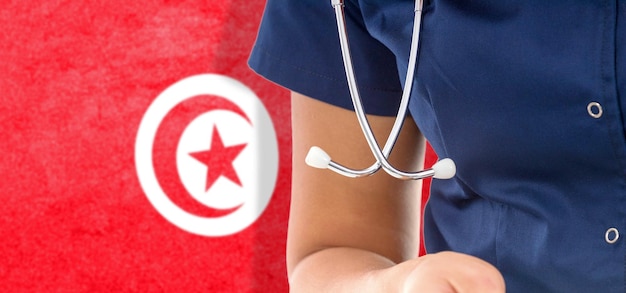 Medico femminile della bandiera della Tunisia con lo stetoscopio, sistema sanitario nazionale