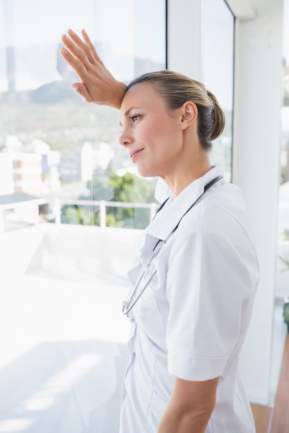 Medico femminile sicuro che osserva attraverso le finestre