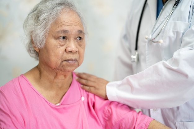 Medico fisioterapista infermiere asiatico che tocca paziente donna anziana asiatica anziana o anziana con amore, cura, aiuto, incoraggiamento ed empatia nel reparto ospedaliero di cura, concetto medico sano e forte