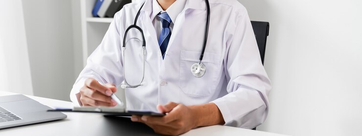 Medico in possesso del file di referto del paziente per valutare i sintomi sulla scrivania.