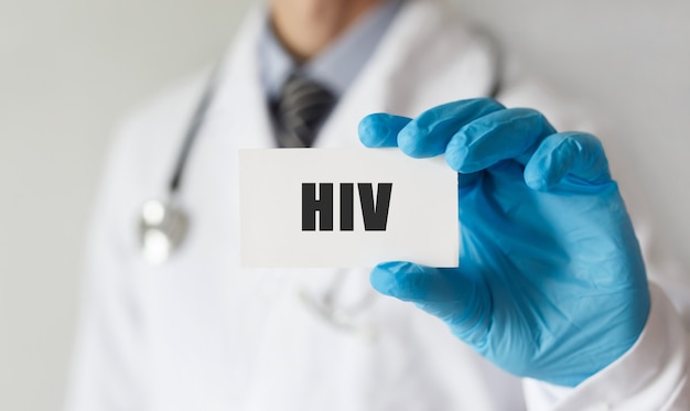 Medico in possesso di una carta con testo HIV, concetto medico