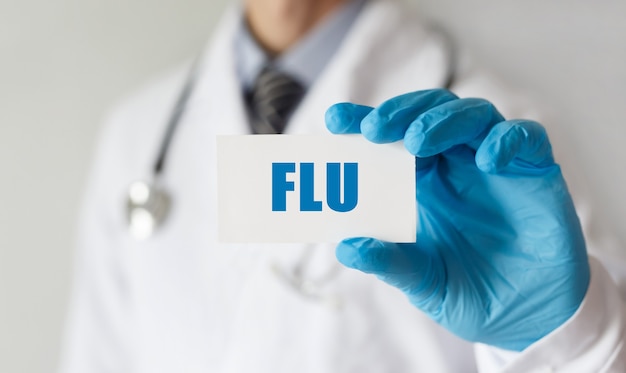 Medico in possesso di una scheda con testo FLU, concetto medico