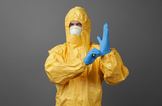 Medico in una tuta protettiva con mascherina medica e guanti protettivi