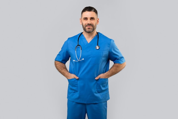 Medico lavoratore ritratto di fiducioso medico di mezza età in uniforme blu guardando la fotocamera in posa