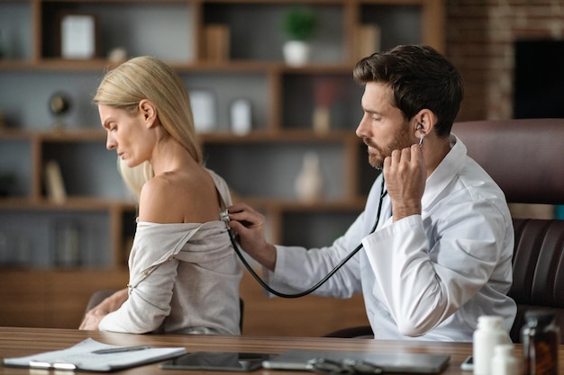 Medico maschio che fa controllo medico fino al paziente femminile in clinica