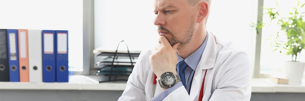 Medico maschio che guarda lo schermo del laptop in ufficio