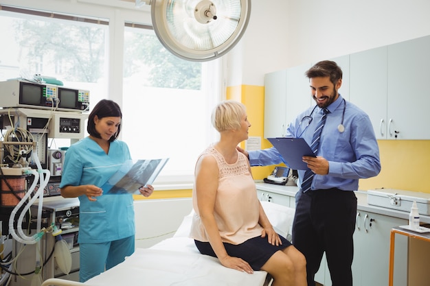 Medico maschio che interagisce con un paziente mentre infermiere che esamina raggi x