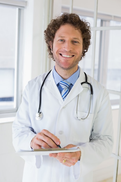 Medico maschio felice con i appunti in ospedale