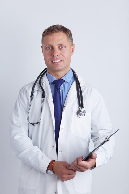 Medico maschio in piedi con la cartella isolata su sfondo bianco