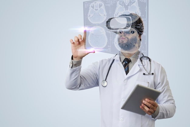 Medico maschio su un muro grigio, utilizzando occhiali per realtà virtuale, guardando uno schermo virtuale