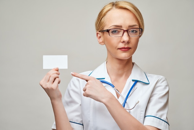 Medico o infermiere dell'operaio medico che mostra biglietto da visita in bianco