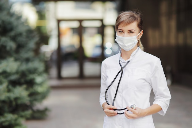 Medico o infermiere donna che indossa una maschera protettiva per il viso Covid19