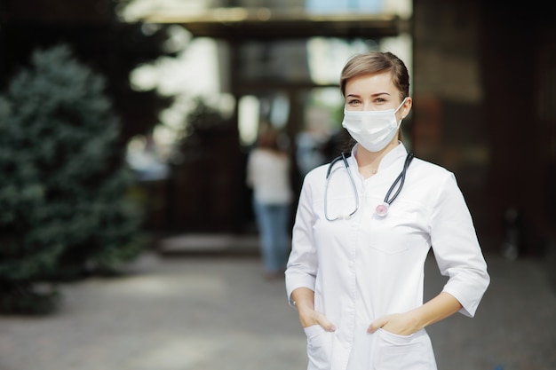 Medico o infermiere donna che indossa una maschera protettiva per il viso Covid19