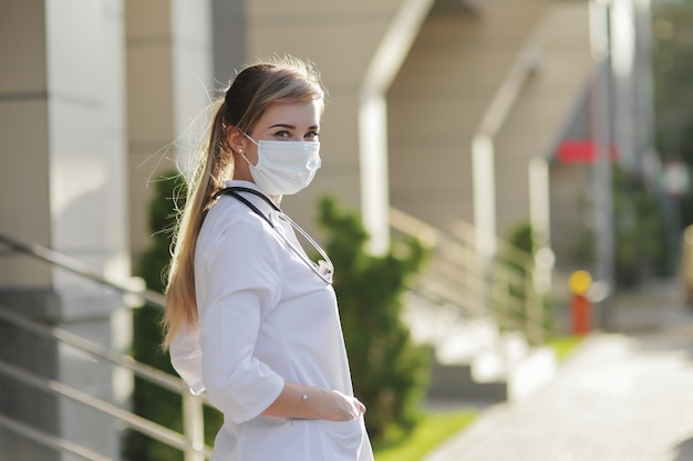 Medico o infermiere donna che indossa una maschera protettiva per il viso Covid19