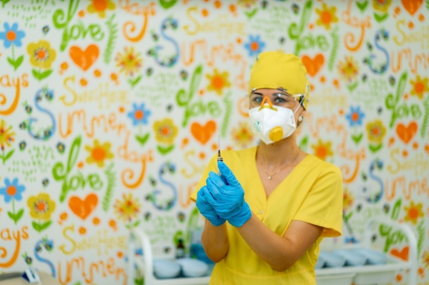 Medico o infermiere mano in guanti blu che tengono la siringa con il vaccino per un bambino o un adulto. Medicina e concetto di droga.