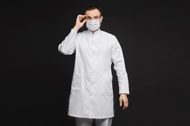 Medico o medico in posa in maschera e occhiali protettivi