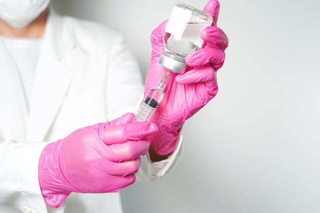 medico o scienziato con una siringa con ampolle bottiglia di vaccino per iniezione
