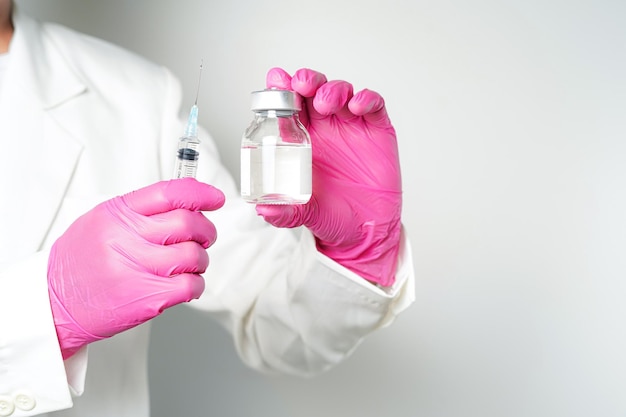 medico o scienziato con una siringa con ampolle bottiglia di vaccino per iniezione