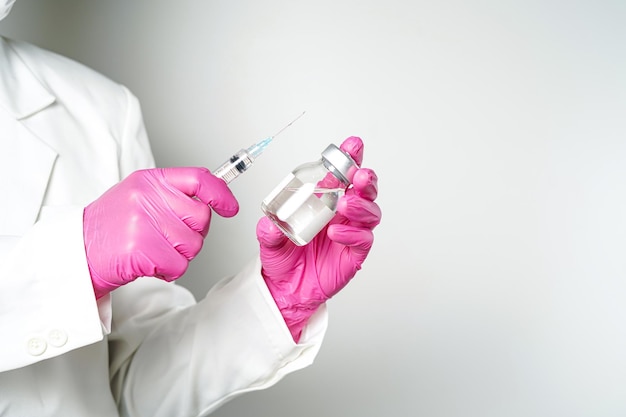 medico o scienziato con una siringa con ampolle bottiglia di vaccino per iniezione