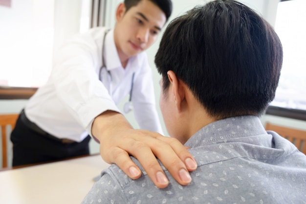 Medico paziente confortante nella stanza di consultazione.