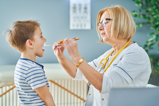 Medico pediatra che esamina i bambini in clinica. Foto di alta qualità