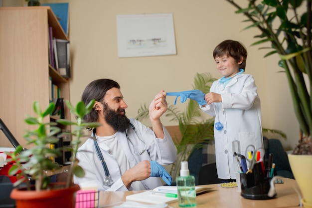 Medico pediatra che esamina un bambino in uno studio medico confortevole