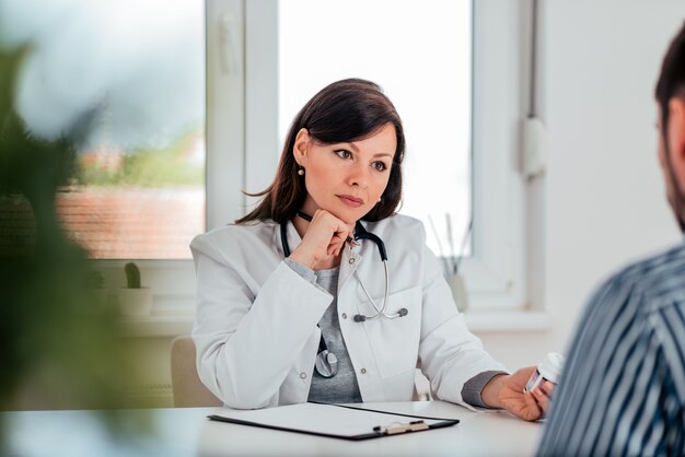 Medico pensieroso con un paziente in ufficio.