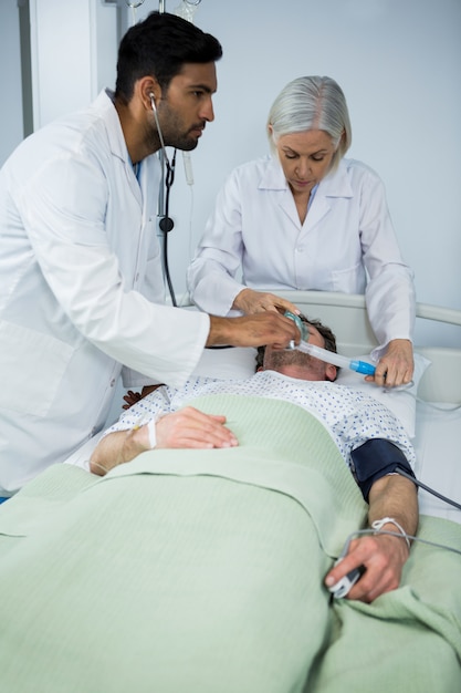 Medico posizionando una maschera di ossigeno sul viso di un paziente