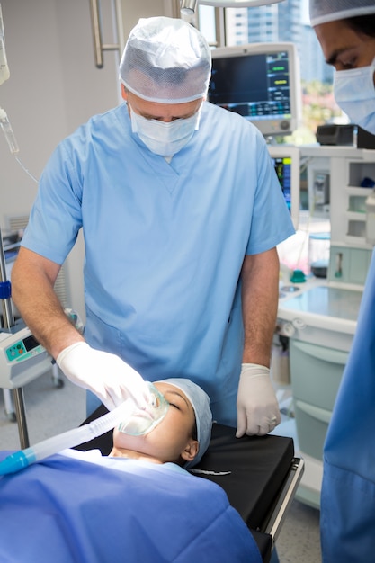 Medico posizionando una maschera di ossigeno sul viso di un paziente