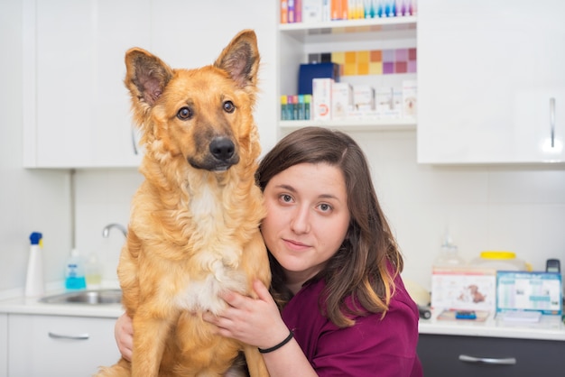 Medico presso la clinica veterinaria che abbraccia un bel cane