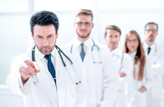 Medico rigoroso che ti indica in piedi nel concetto di assistenza sanitaria sul posto di lavoro