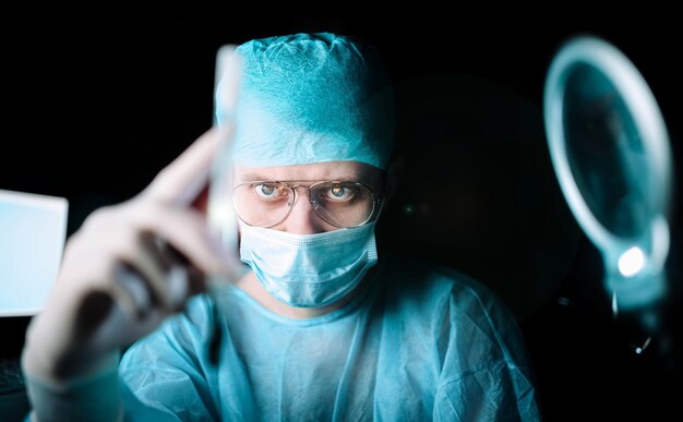 medico scienziato di notte in laboratorio esamina il virus in vitro