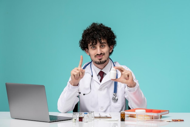 Medico serio carino bello medico che lavora al computer in camice chiedendo di dare un minuto