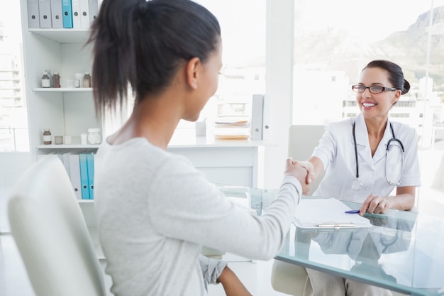 Medico sorridente che agita la mano dei pazienti