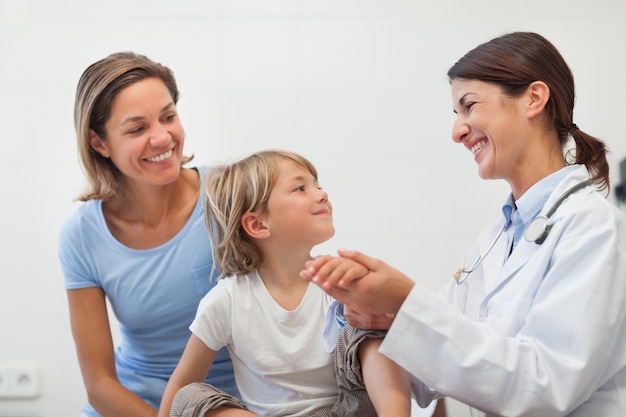 Medico sorridente che auscultating l&#39;avambraccio di un bambino