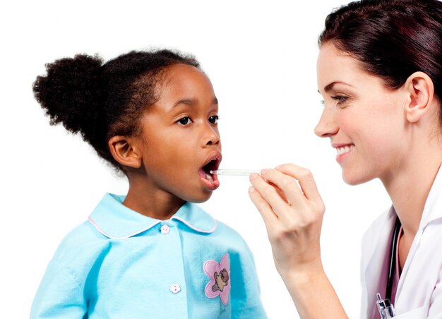 Medico sorridente che prende la temperatura della bambina