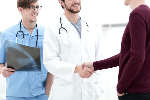 Medico sorridente che stringe la mano a un paziente