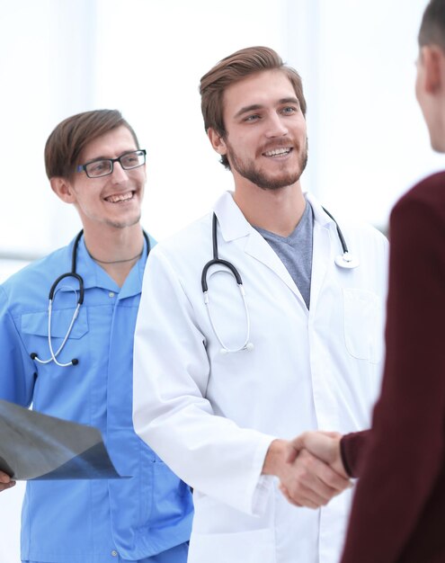 Medico sorridente che stringe la mano a un paziente