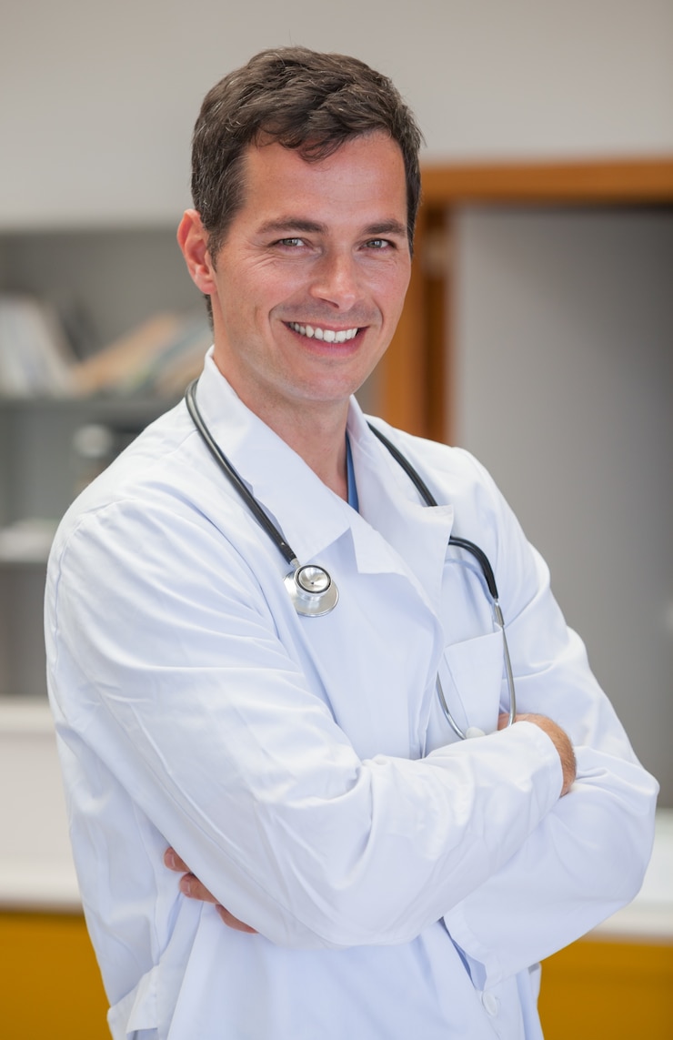 Foto medico sorridente con le braccia incrociate
