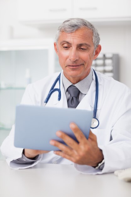 Medico sorridente utilizzando un tablet PC
