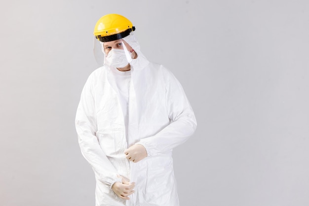 Medico stanco che indossa maschera e guanti in ospedale in tempi di coronavirus controllando il suo smartphone