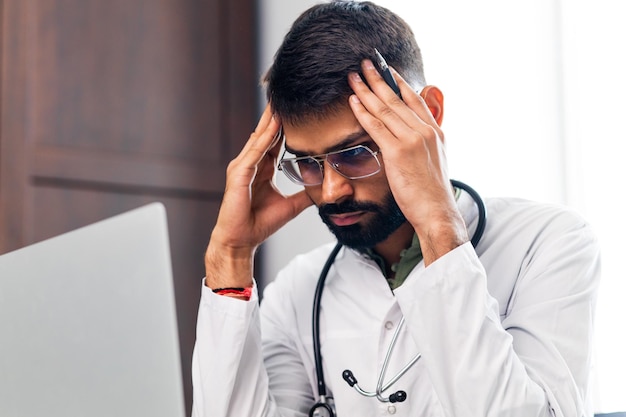 Medico stanco in clinica durante una lunga giornata di lavoro a tempo pieno