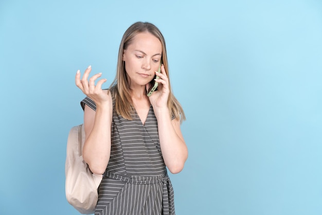 Medio caucasico in abiti casual con zaino e telefono cellulare a parlare