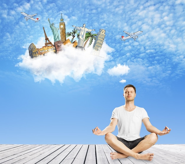 Meditando un ragazzo europeo che pensa al viaggio sullo sfondo del cielo blu Concetto di vacanza e di vacanza